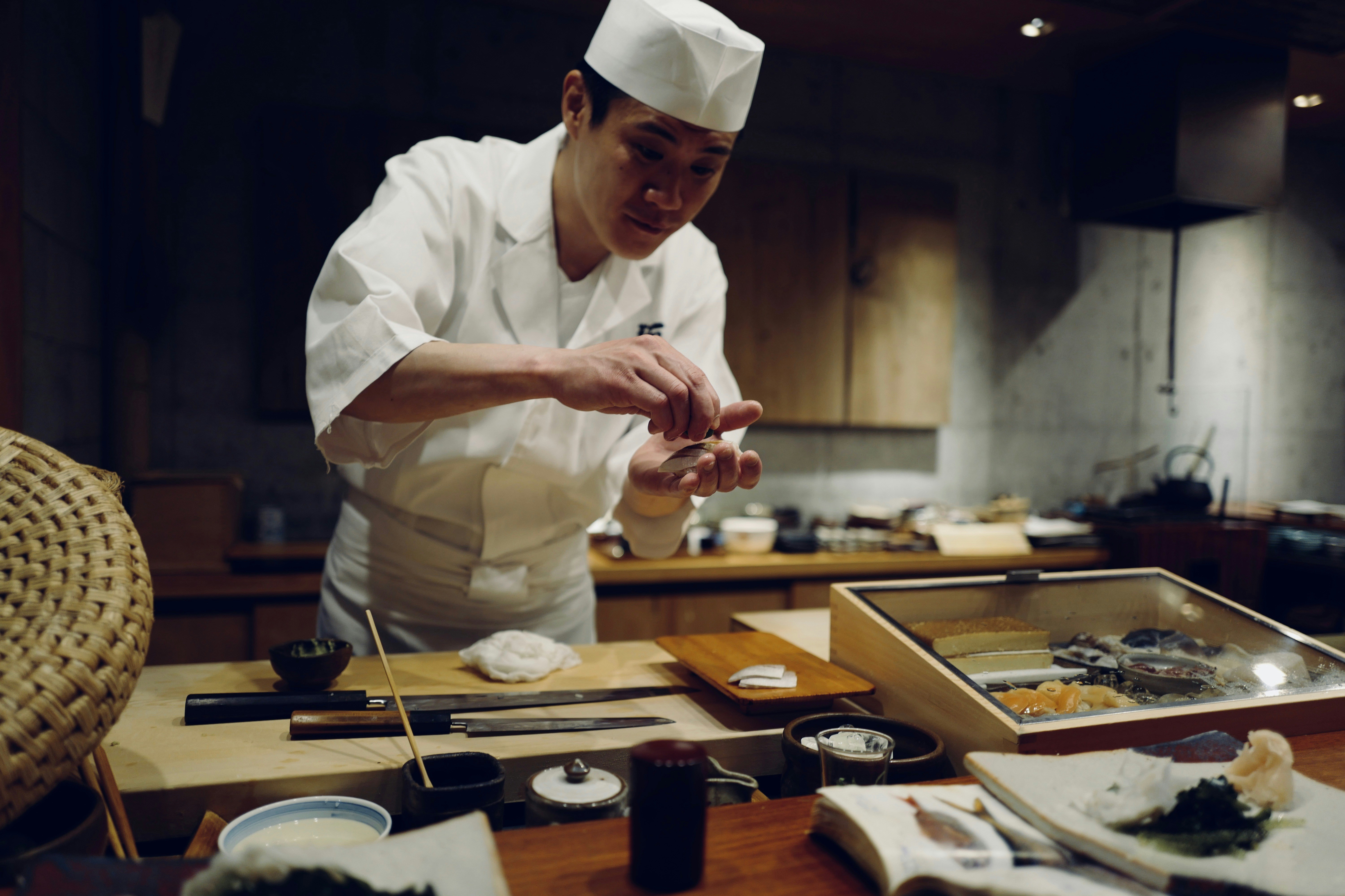 A picture of sushi being made by a chef.