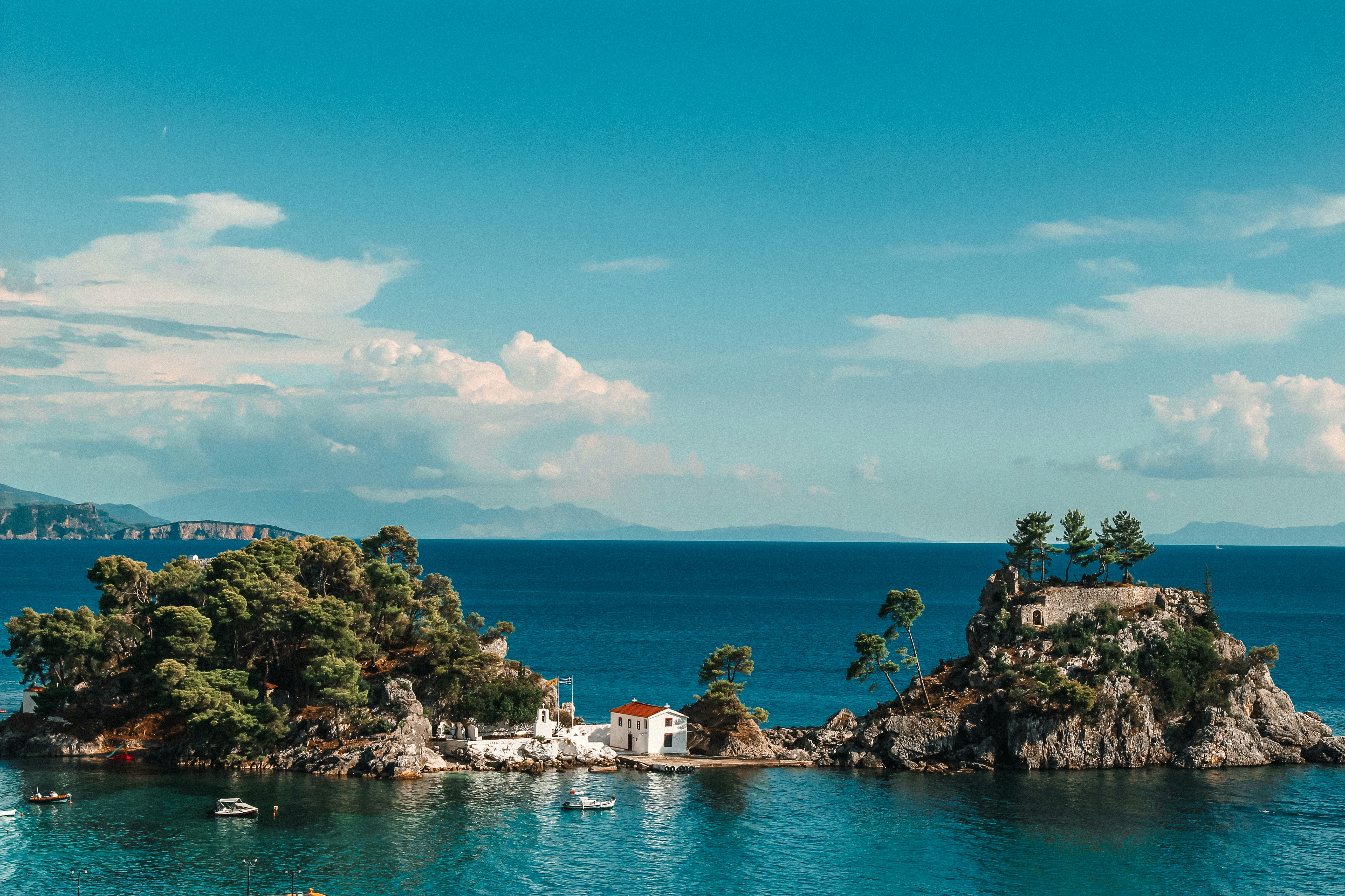 Aerial shot of a house between two hills on an island in Parga Greece.